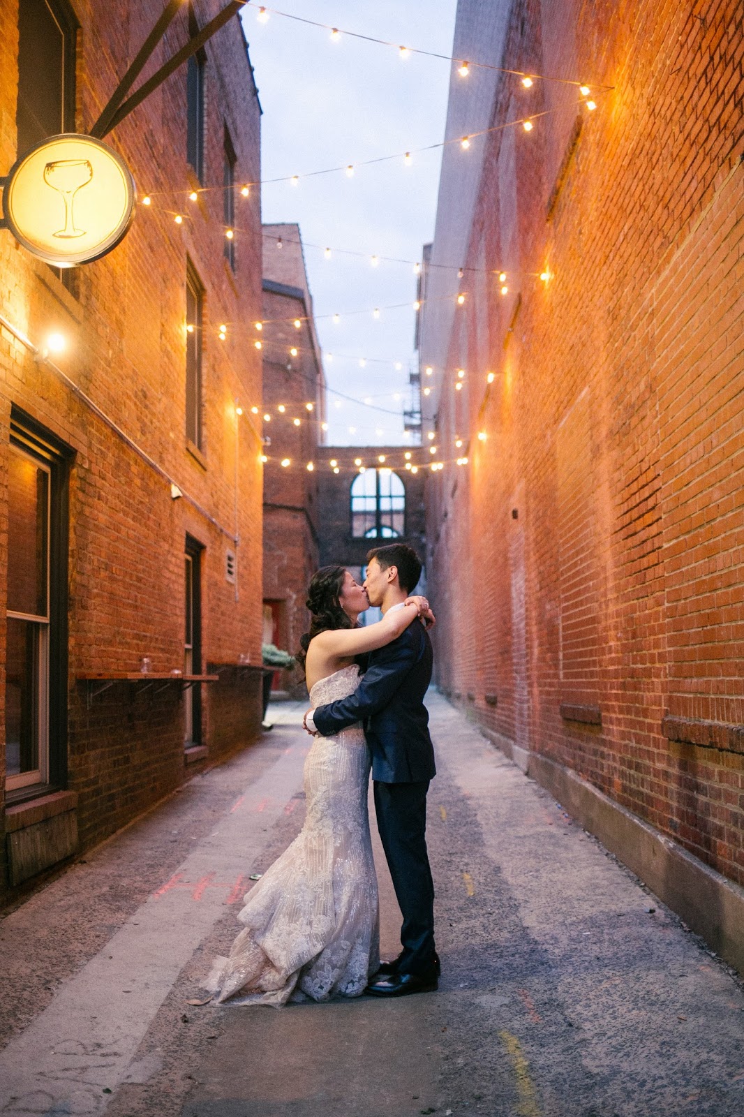 Man and Wife kissing in the street under pretty lights